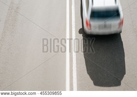 Top View Of Fast Moving Car On Road. Blurred Motion, Selective Focus On Dividing Double Solid Markin