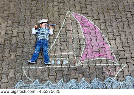 Little Kid Boy As Pirate On Ship Or Sailingboat Picture Painting With Colorful Chalks On Asphalt. Cr