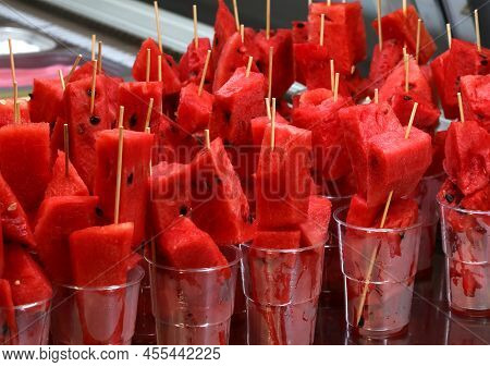 Skewers Of Large Slices Of Ripe Red Watermelon In The Glasses For Sale In The Outdoor Bar Of The Tro