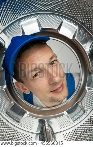 Smiling Curious Male Repairman In Uniform Got His Head Into The Drum Of The Washing Machine, Photo F