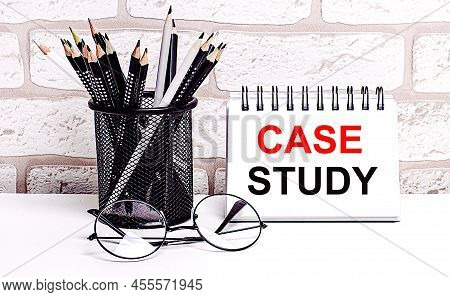 A Workplace In The House With Glasses, Pencils In A Stand And A Notebook With Text Case Study On A B