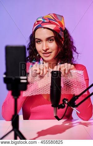 Attractive Young Woman In Stylish Outfit Creating Content For Asmr Blog Popping Bubble Wrap On Mic A