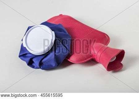Red Medical Water Heater And Blue Ice Bag On A White Background. The Concept Of Treating Diseases Wi
