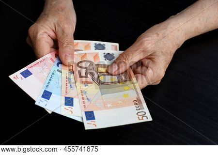 Elderly Woman With Euro Notes In Wrinkled Hands. Concept Of Pension Payments, Savings At Retirement,