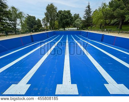 A Half Filled Olympic Swimming Pool With The Bottom Painted Blue And The Lines Of The Alleys In Whit