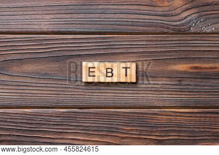 Ebt Word Written On Wood Block. Abbreviation Earnings Before Taxes Text On Cement Table For Your Des