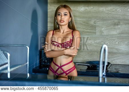 Asian Woman In Dark Red Sexy Lingerie Posing At The Kitchen
