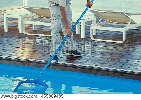 Hand Of Afro Maintenance Pool Cleaner During His Work. Afro Hotel Staff Worker Cleaning The Pool