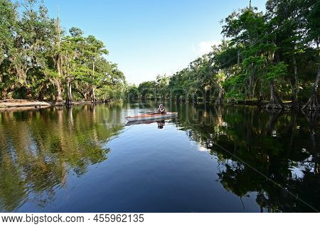 Woman Kayaking On Fisheating Creek Near Palmdale, Florida On Calm Summer Afternoon.