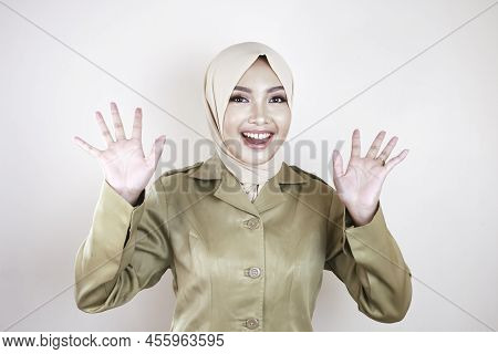 Moslem Civil Worker Wearing Brown Uniform And Hijab Greeting With A Hand Gesture And Smiling At The
