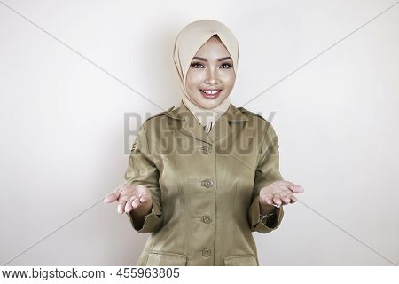 A Young Beautiful Asian Muslim Worker Wearing A Brown Uniform And Hijab Is Presenting. Indonesian Pn