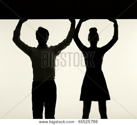 Young couple silhouette holding board