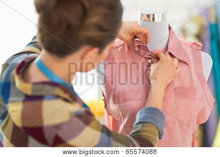 Seamstress Adjusting Clothing On Mannequin. Rear View