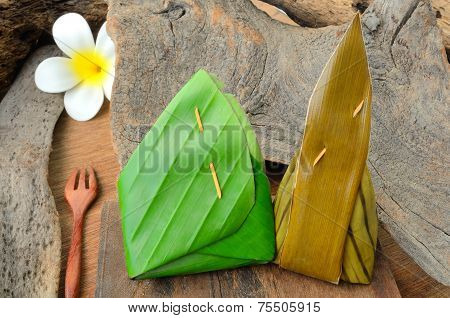 Thai Dessert Sticky Rice Wrapped In Banana Leaf On Wood Background.