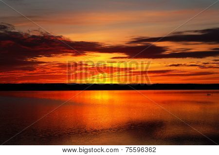 Beautiful fiery sunset over -rozovyfy large lake.