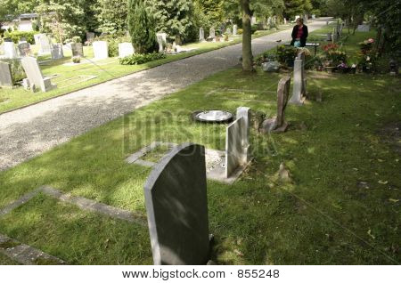 donna in lutto sopra la tomba nel cimitero