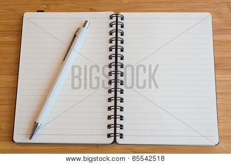 Note book with pencil on a wooden desk