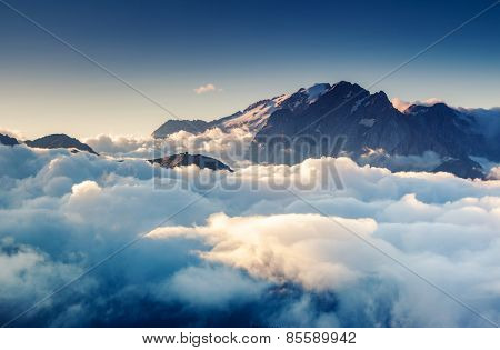 Great view of the foggy Val di Fassa valley with pass Sella. National Park. Dolomites (Dolomiti), South Tyrol. Location Canazei, Campitello, Mazzin. Italy, Europe. Dramatic scene. Beauty world.