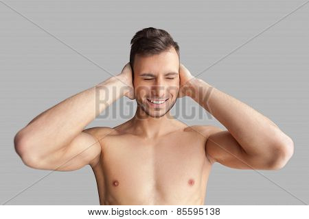 Can't Hear It Anymore. Handsome Young Muscular Man Covering His Ears With Hands And Keeping Eyes Clo