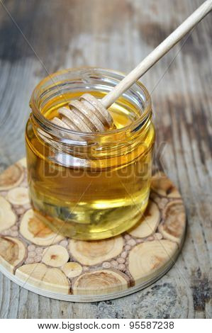 Golden honey with honeystick. cinnamon and anise stars on wooden table