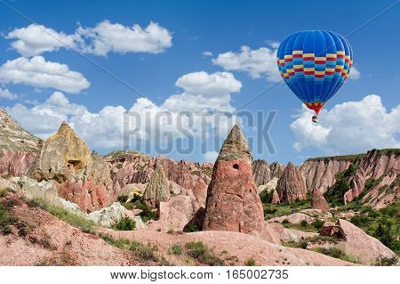 Colorful hot air balloon flying over Red valley at Cappadocia Anatolia Turkey. Volcanic mountains in Goreme national park.