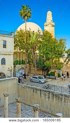 JERUSALEM ISRAEL - FEBRUARY 16 2016: The Huvra Synagogue behind the trees with the columns of Cardo on the foreground on February 16 in Jerusalem
