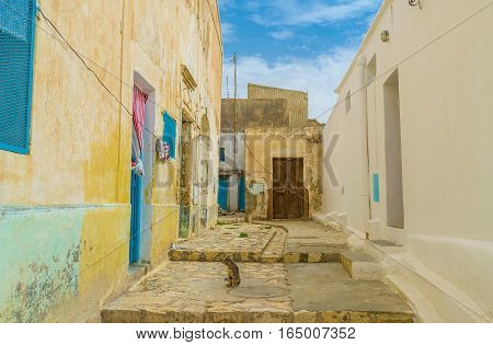 The small yard in old residential neighborhood of El Kef with crumbling walls and wooden doors Tunisia.