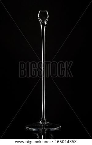 The tall glass candlesticks against black background