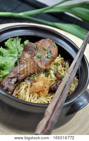 Black bowl of chicken drumstick with egg noodle