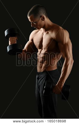 Focused on fitness. Masculine shirtless male pumping iron showing off his sexy ripped body