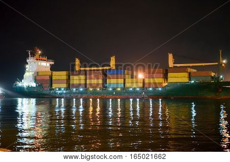 GEORGIA BATUMI - NOVEMBER 24/2014: Huge tanker is moored at night in the sea port for unloading containers.