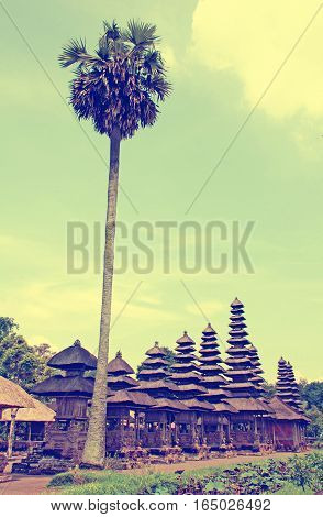 Palm and Taman Ayun Temple in Mengwi (Bali Indonesia) on a beautiful sunny day. Vintage toned image