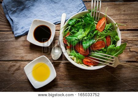 fresh mix of lettuce salad with tomato with seasoning oil