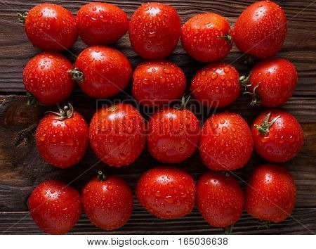 Red tomatoes with water drops. Tomatoes of different varieties. omatoes background. Fresh tomatoes Healthy food concept. Colorful festive still life. Loosely laid tomatoes in different positions.