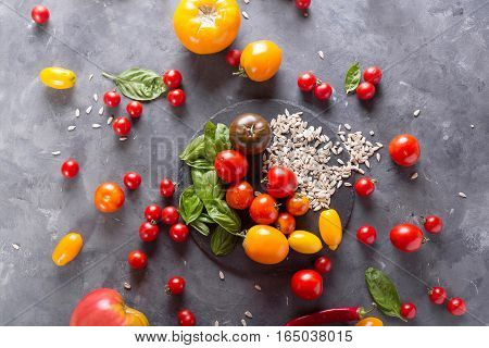 Tomatoes of different varieties. Colorful tomatoes Tomatoes background. Fresh tomatoes Healthy food concept. Colorful festive still life. Loosely laid tomatoes in different positions.