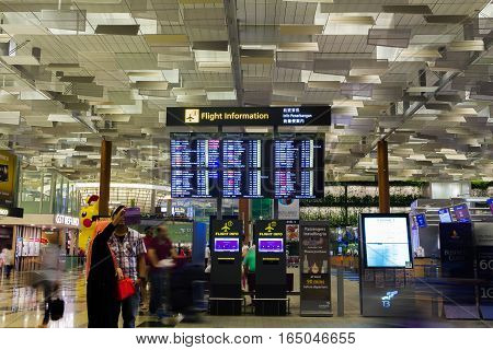 Singapore - January 8, 2017: Couple visitors taking selfie photo with Departure Board in Changi Airport. Departure Hall, it is one of the largest transportation hubs in Asia.