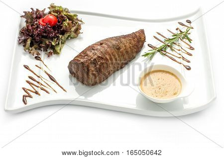 Delicious chateaubriand steak . Veal tenderloin cooked grilled on a white plate on a white background isolated