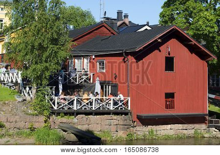 PORVOO, FINLAND - JUNE 13, 2015: A view of summer cafe on the river bank of Porvoyoki in the old city Porvoo. Historical landmark