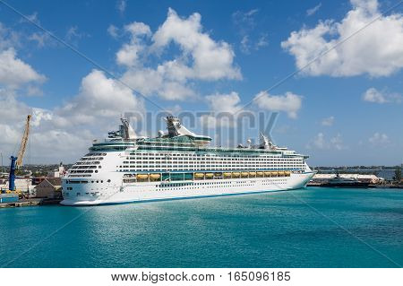 A white luxury cruise ship docked at the freight yard in Bridgetown Barbados