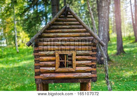 The wooden hut on legs. Fabulous a little house in the woods. Wooden decorative house lawn ornament