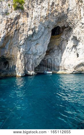 Capri Italy - October 20 2008: A boat with tourists leaving the Arco Naturale sea cave on the south coast