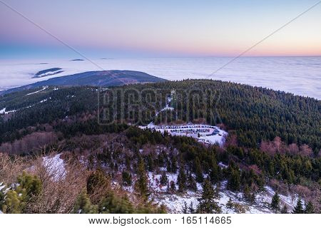 Aerial view from the tower Jested hill to the parking lot below. Inverno valley bathed in fog. Beautifully colored sky after sunset. Cyech Republic