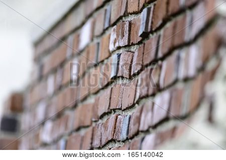 Crooked courses of brick in a roughly built wall