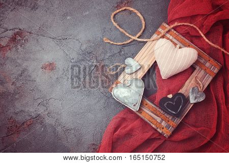 Valentines day background with ristic heart shapes and red cloth. View from above