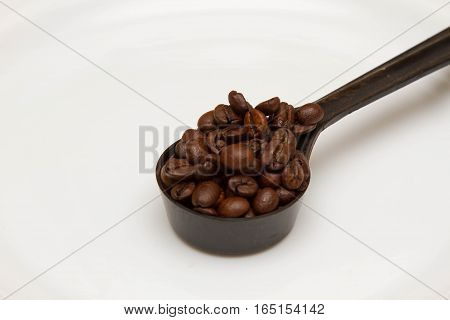 Spoon with coffee grains on a white background, breakfast