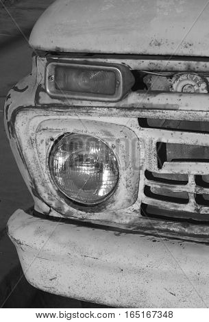 Vintage pick up truck in black and white showing it's rust and it's age.