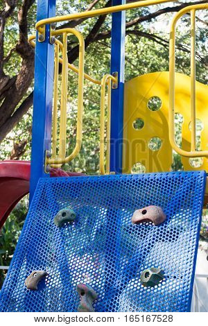 Artificial rock climbing wall at playground stock photo