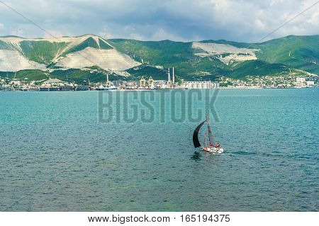 NOVOROSSIYSK RUSSIA - MAY 08.2016:  Sailboat and panorama of Novorossiysk commercial sea port