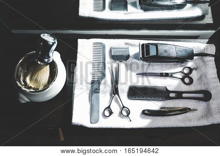 Top view of a shaving kit and a brush lying on a tray with a white towel. Concept of beauty and haircare.