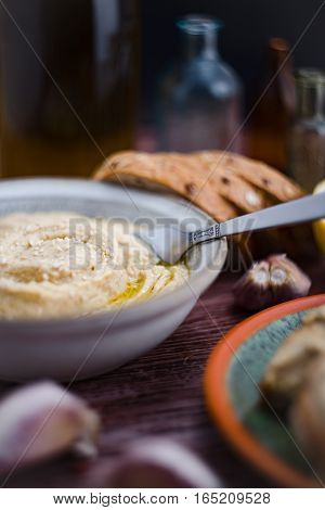The hummus in the gray bowl in a rustic mood.